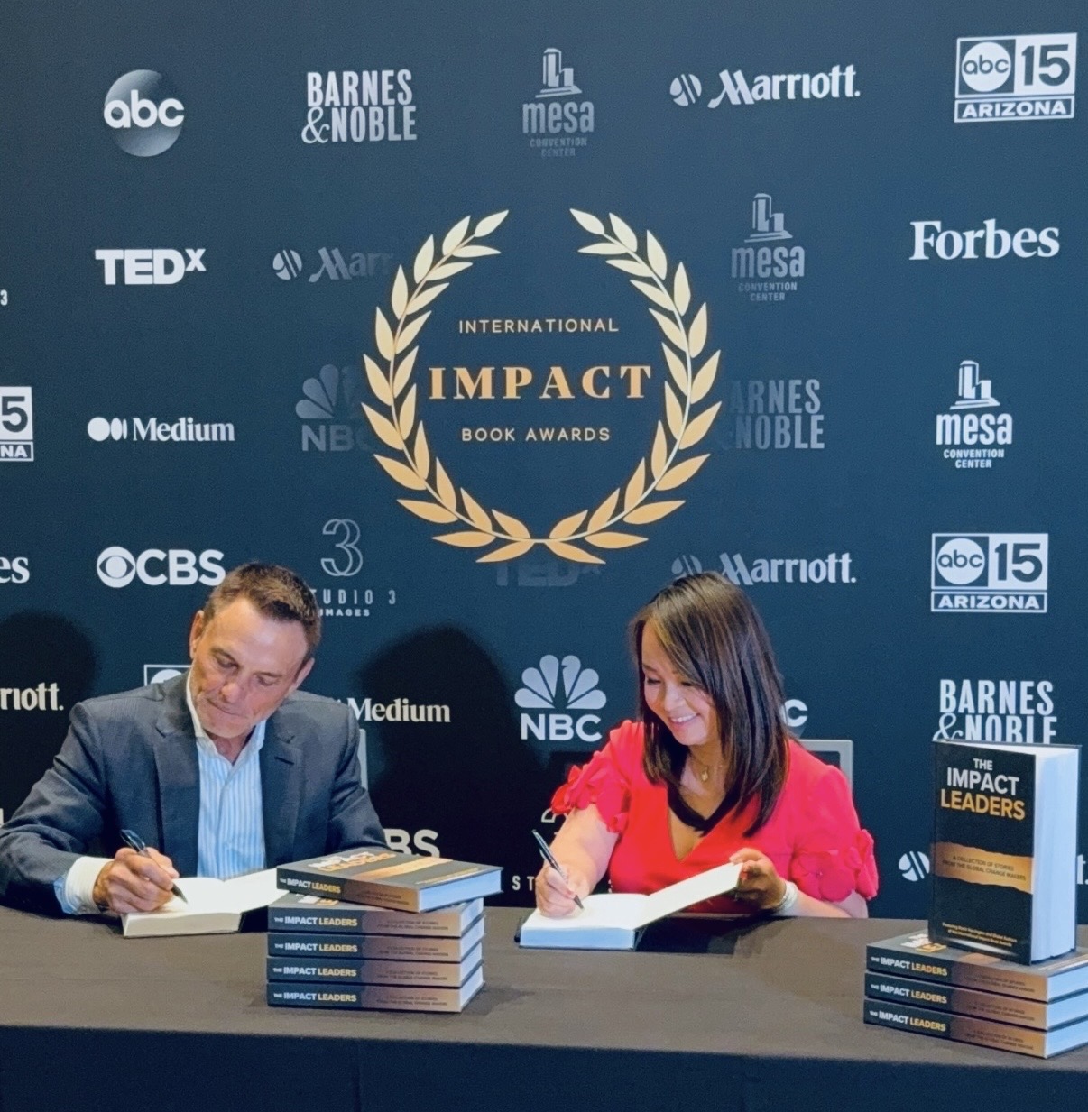 Kimly Hoang-Nakata and Kevin Harrington signing The Impact Leaders