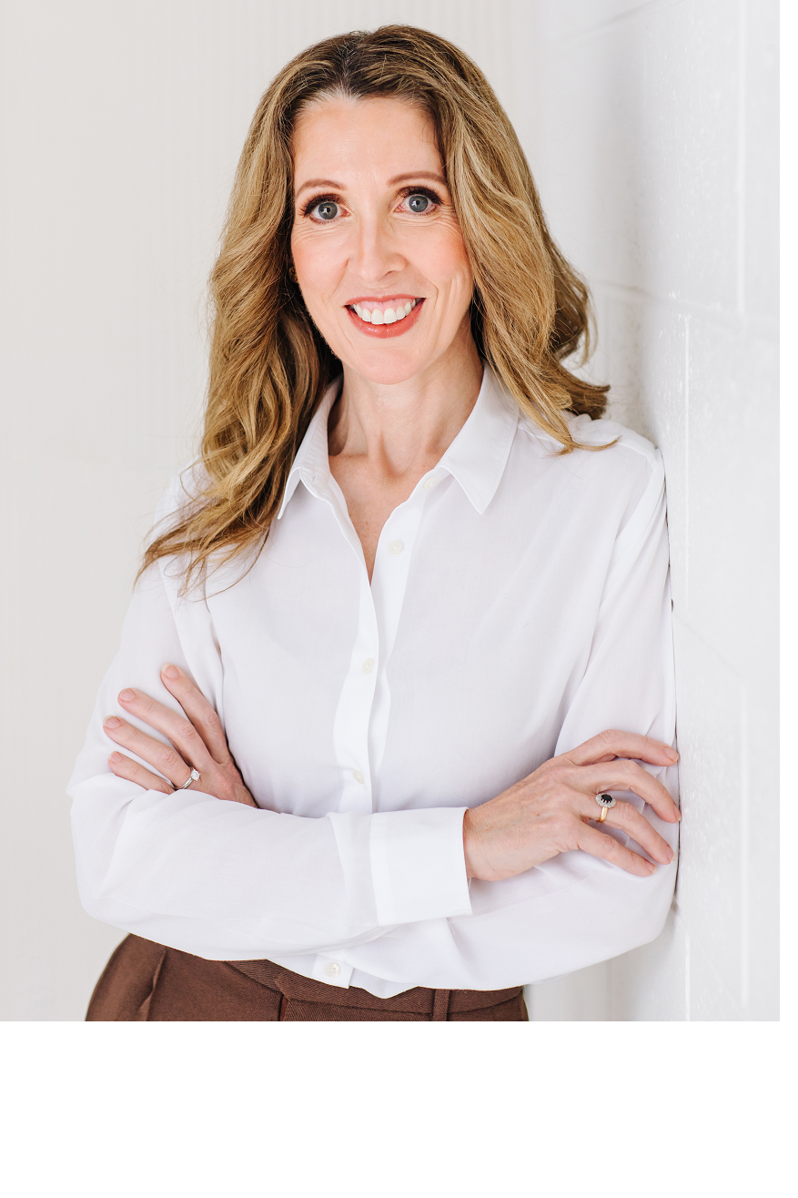 Karen Tisdell, arms crossed, in a white shirt against a light background