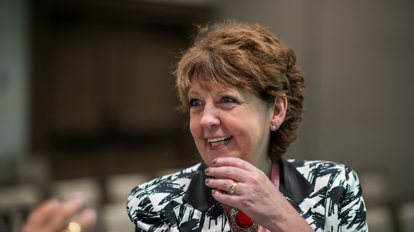 Bernadette McClelland smiling in conversation, wearing a black and white patterned jacket