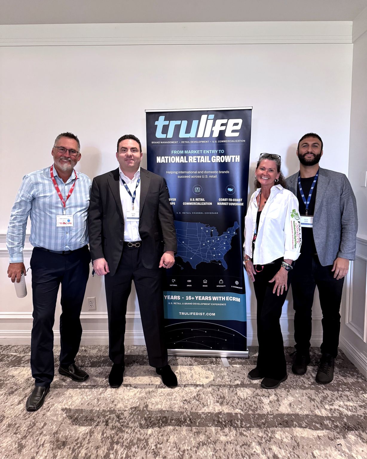 Brian Gould, second from left, with three other people in front of the TruLife Distribution banner