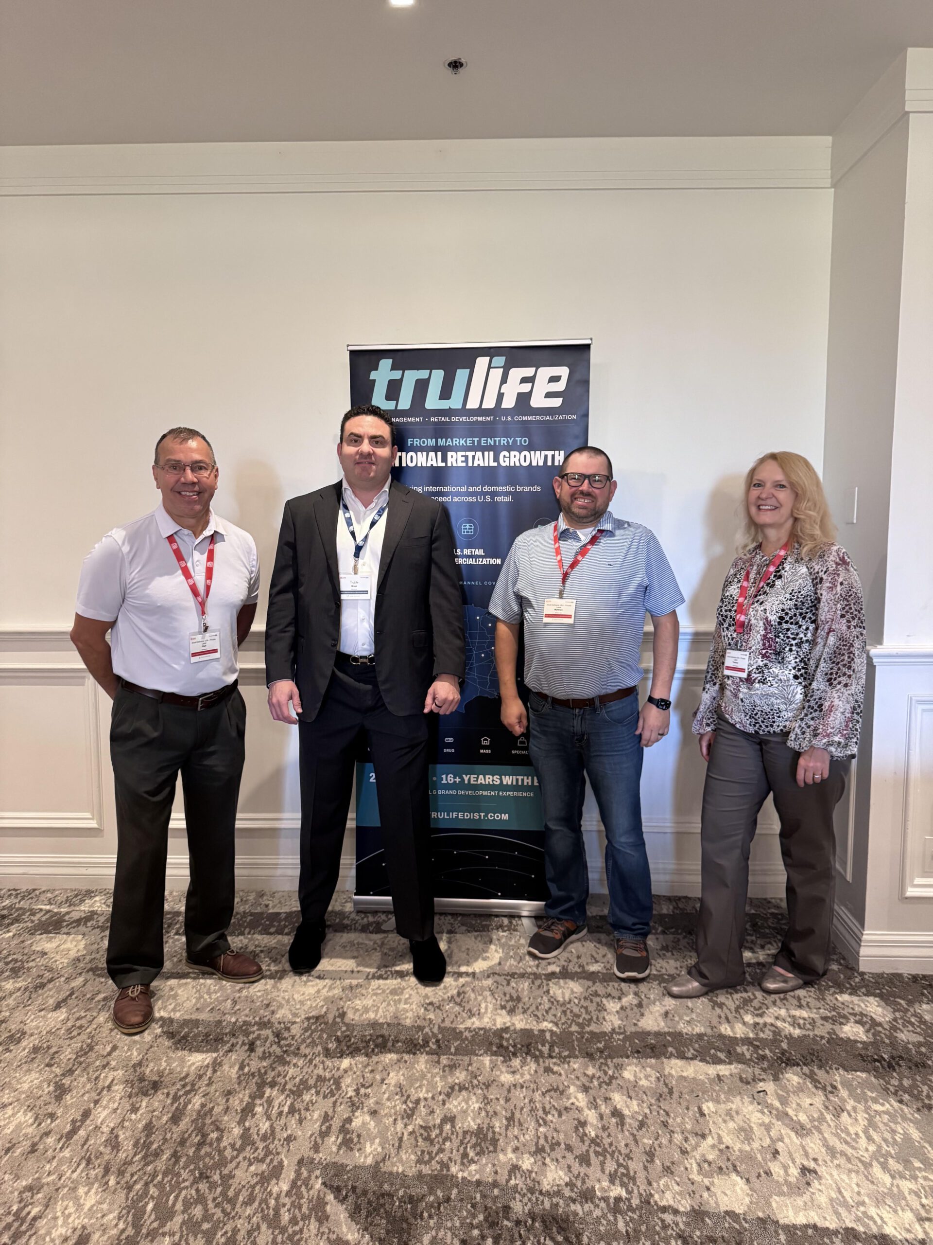Brian Gould, second from left, with three other people in front of the TruLife Distribution banner