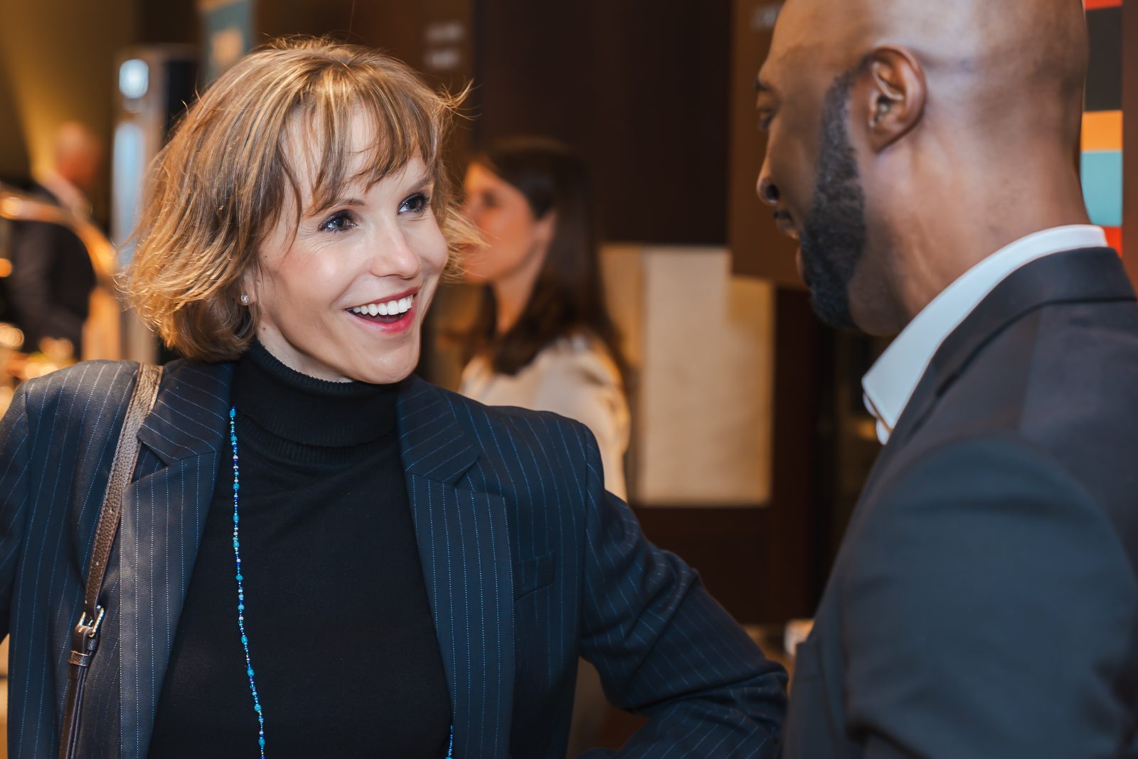 Meike Neitz smiling in conversation with a guest at an event