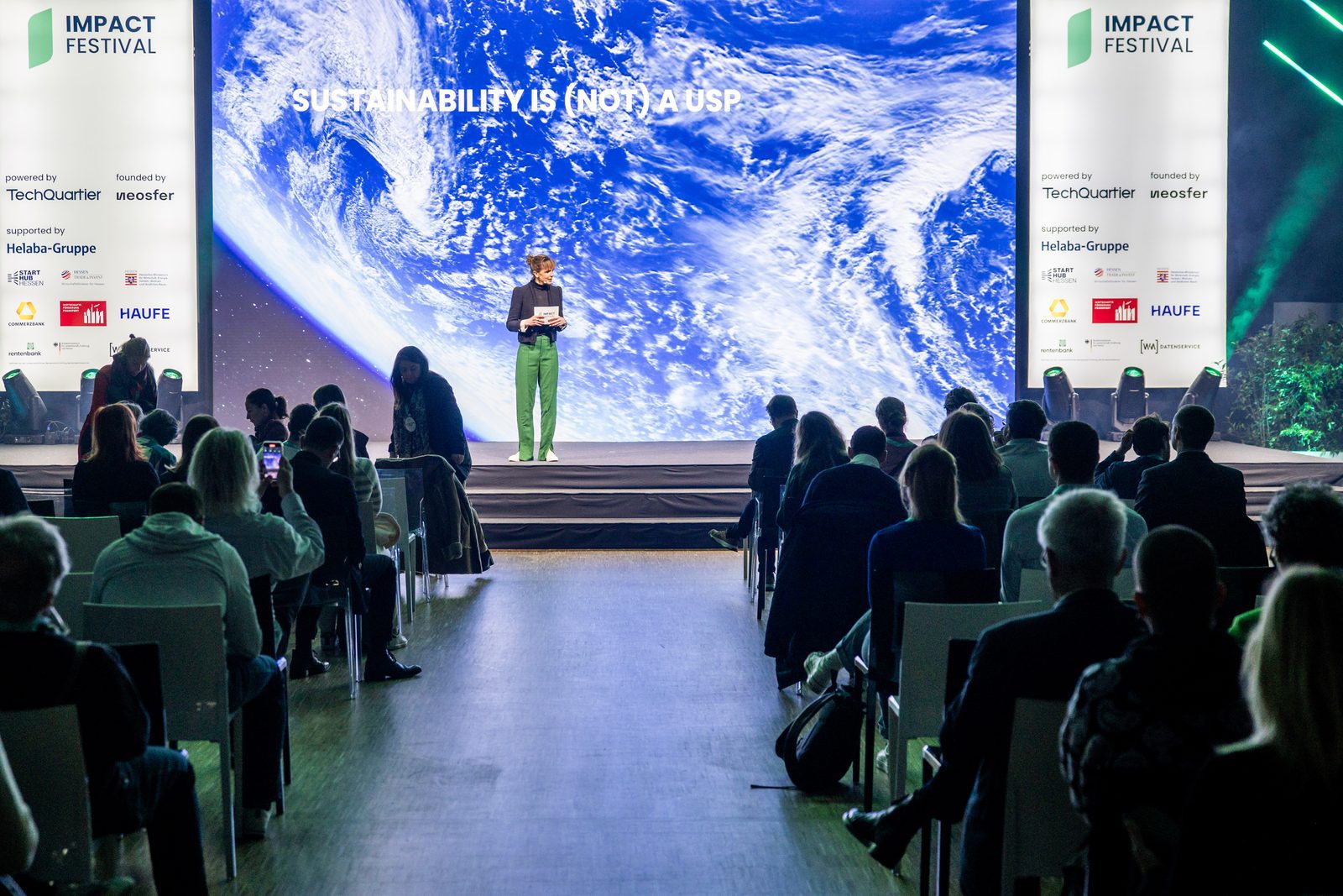 Meike Neitz on stage at Impact Festival, in front of a screen reading Sustainability is (not) a USP