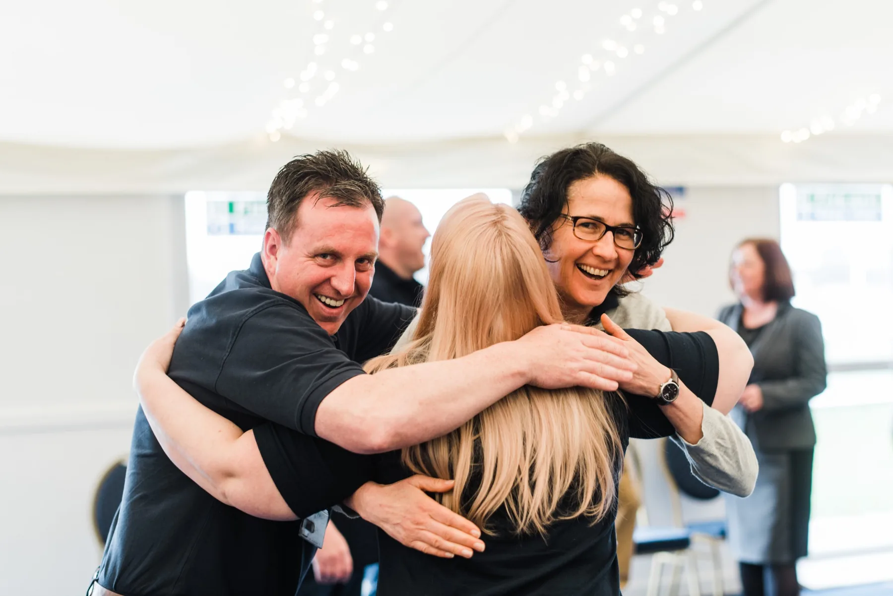 Participants laughing in a group hug at a Joyworks workshop